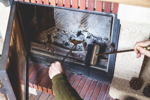 Man cleaning a dirty fireplace