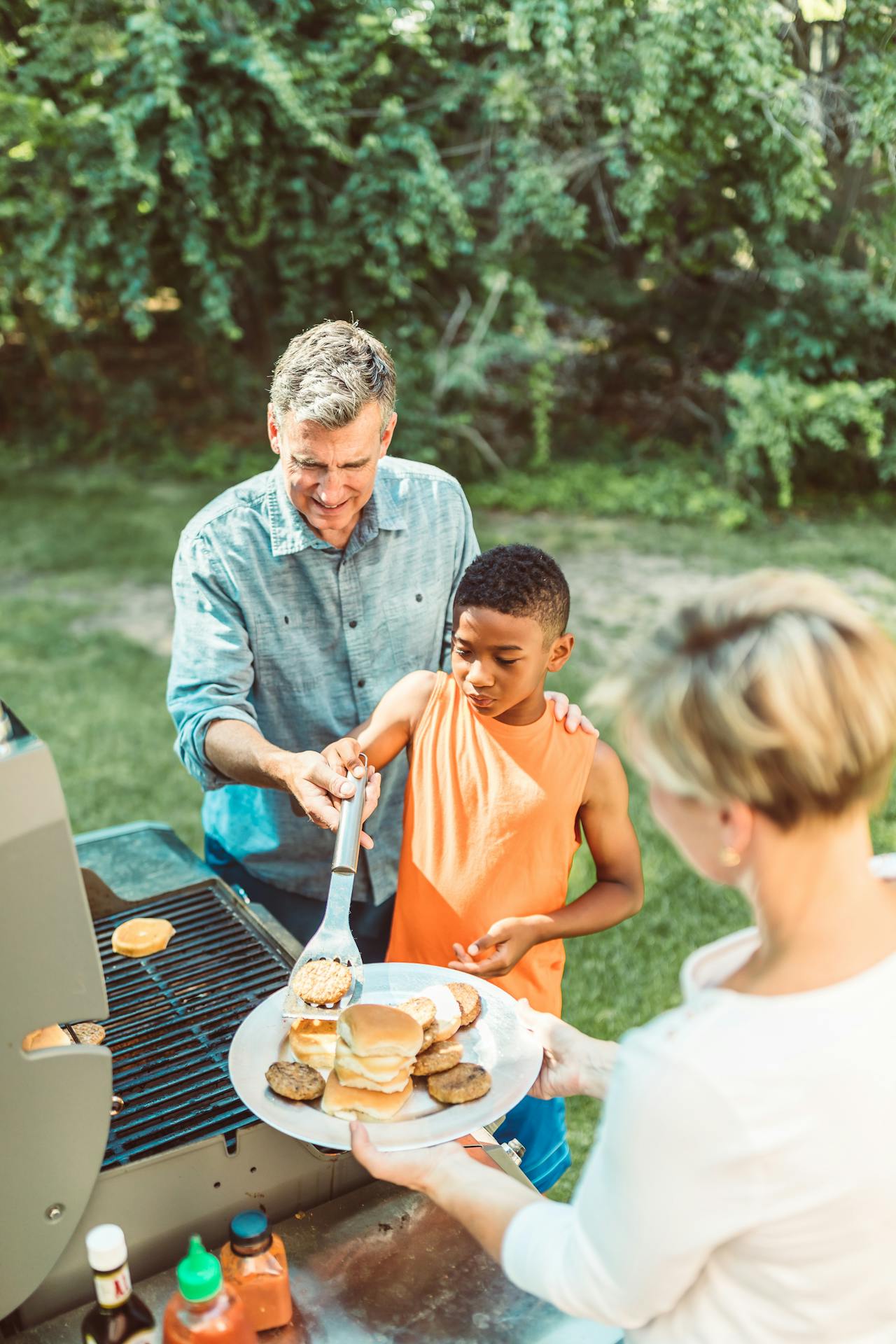 Man teaching young boy to grill Man teaching young boy to grill